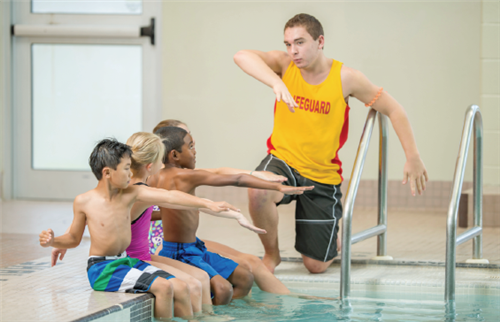 Lifeguard teaching students how to swim 